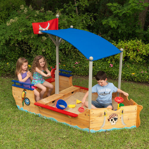 three children playing in kidkraft pirate sandpit playset