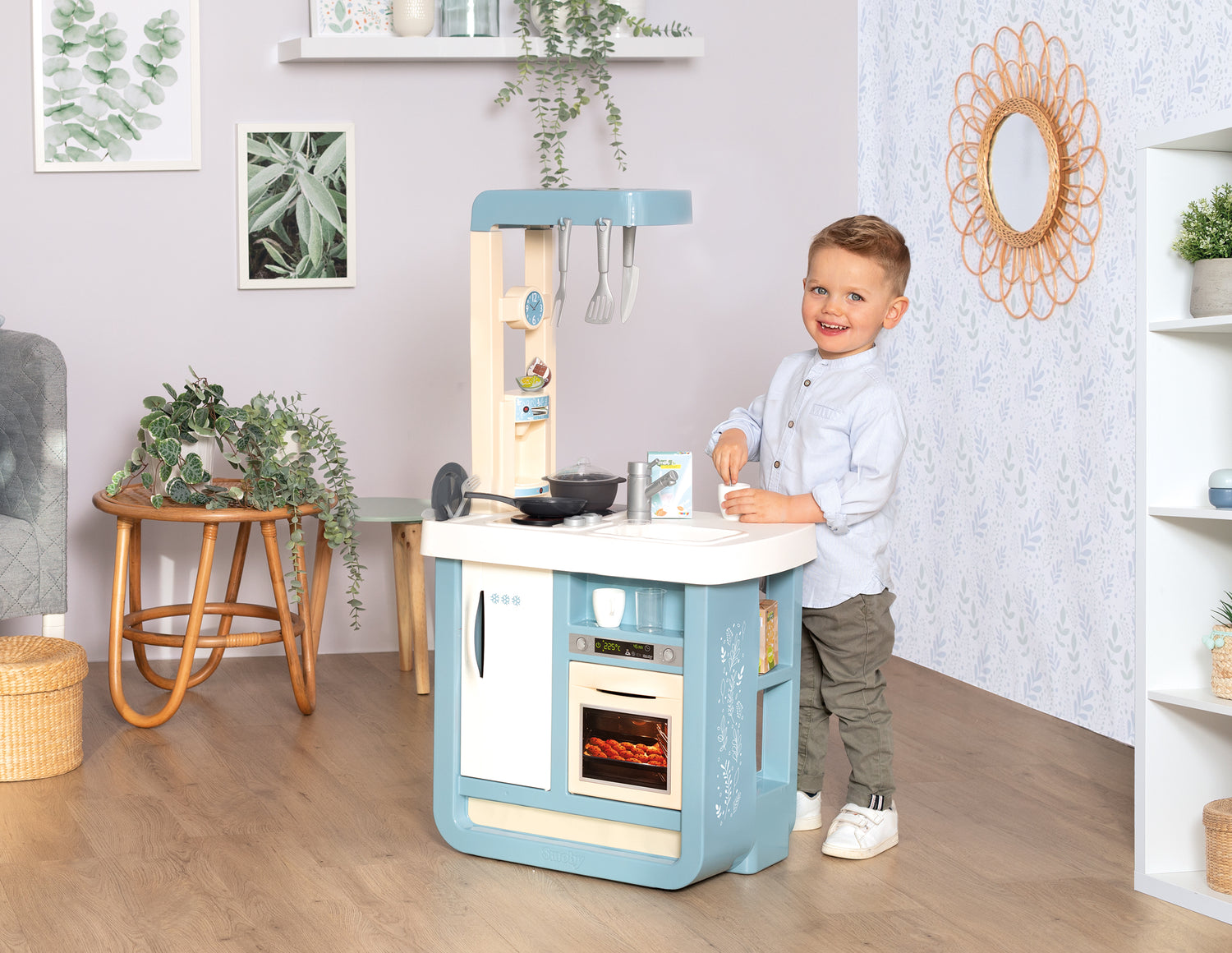 boy standing next to smoby bon appetit kitchen
