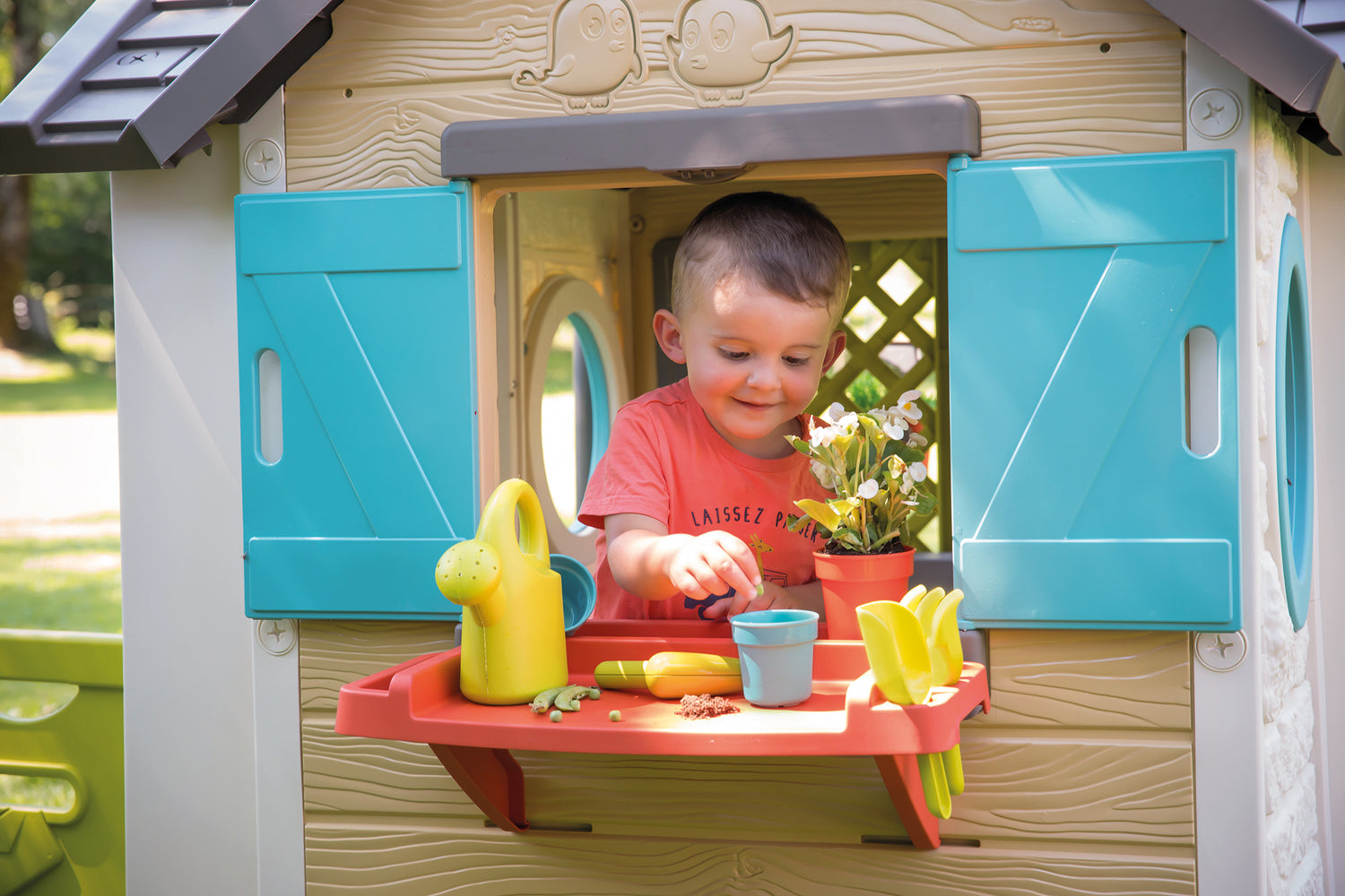 boy in window of smoby garden house