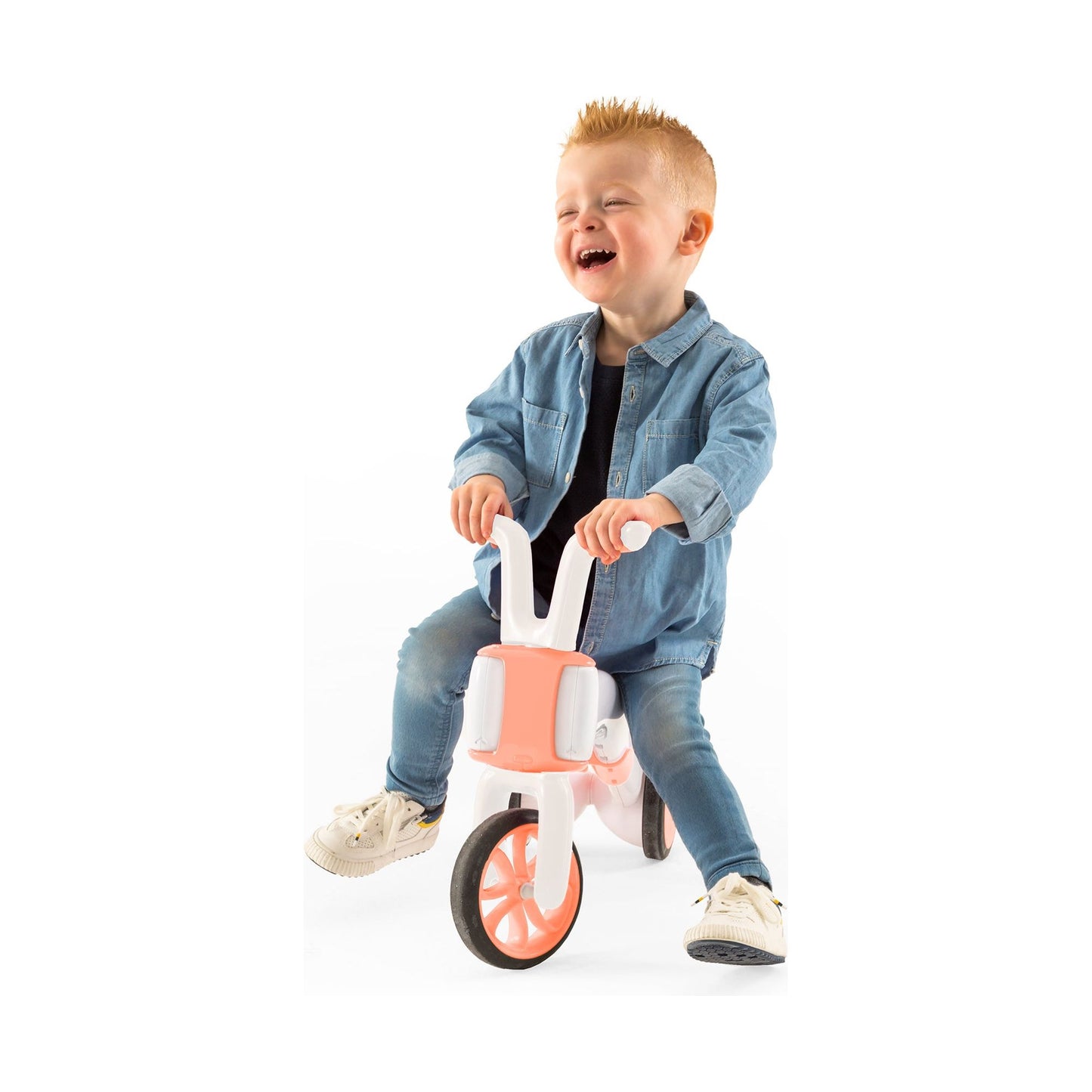 smiling boy riding Chillafish BUNZI Trike Flamingo