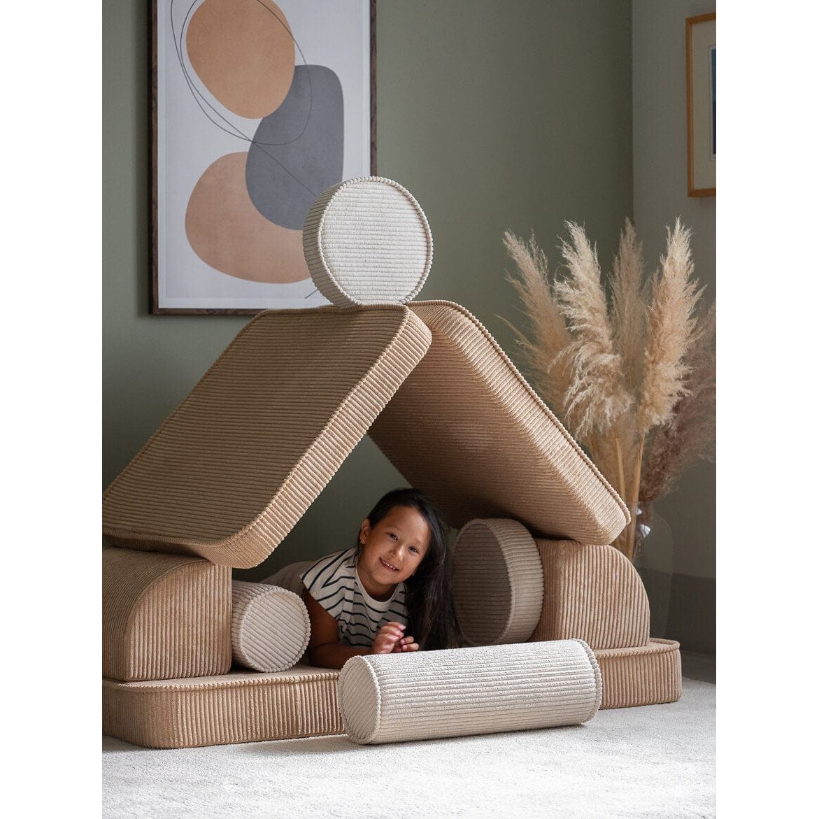 girl sitting under cushions of Wigiwama Brown Sugar Settee