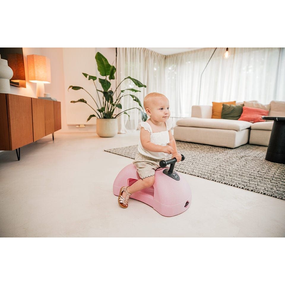 baby sitting on Scoot and Ride My First 3-in-1 Baby Walker & Ride on - Rose in lounge