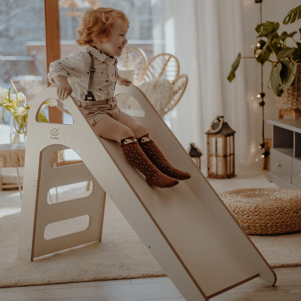 boy sliding down meowbaby indoor slide
