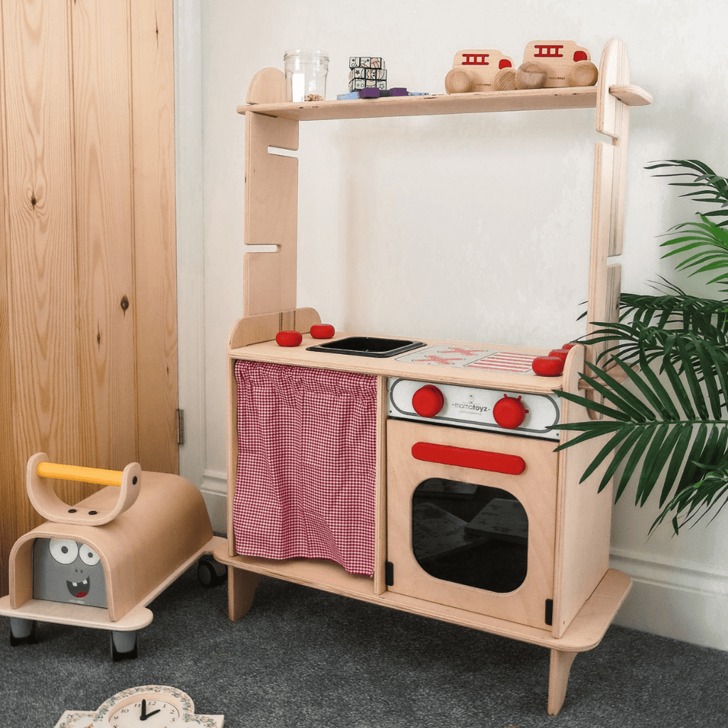 MamaToyz Sera Wooden Kitchen with monster ride on next to it