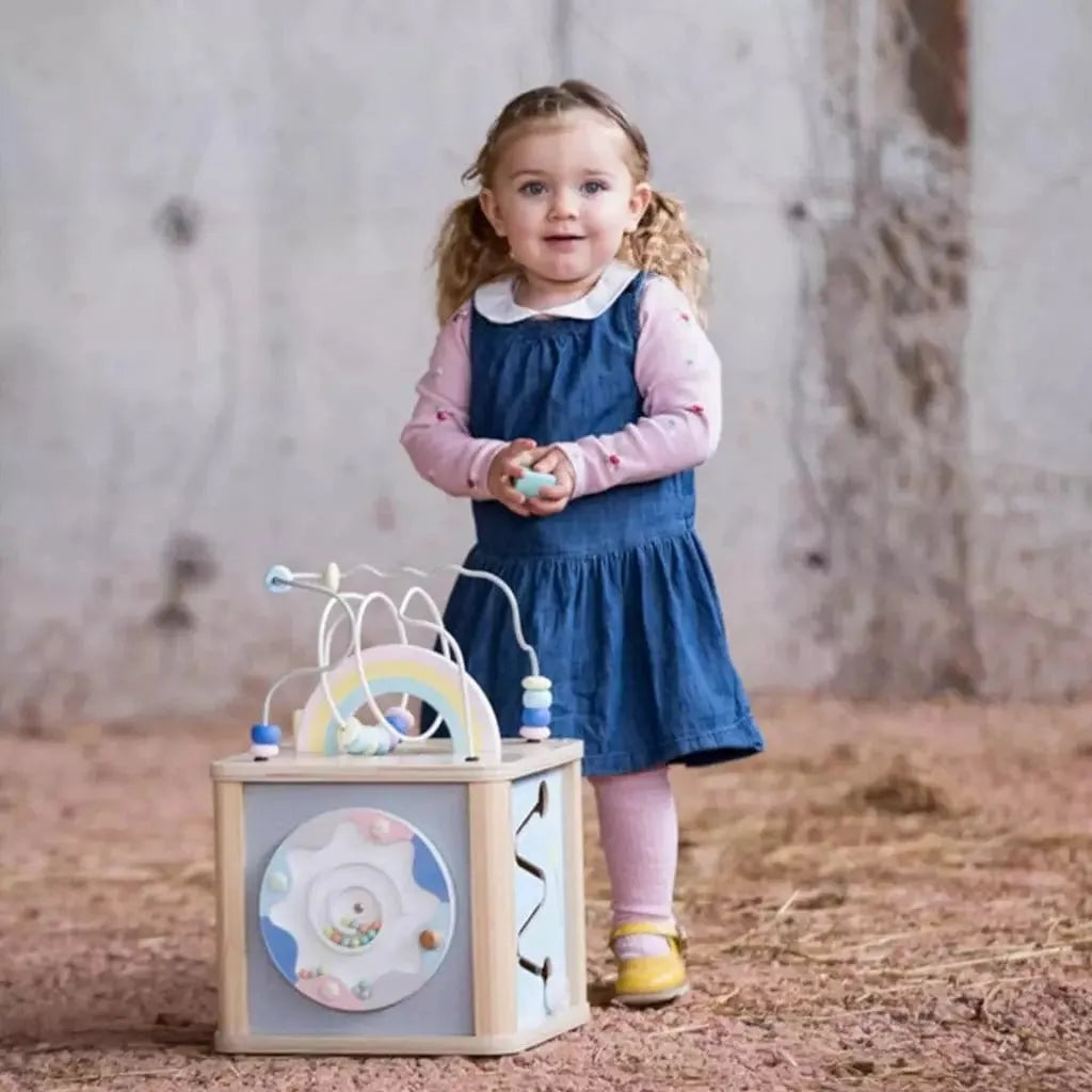 little girl standing with Classic World Wooden Dream Activity Cube