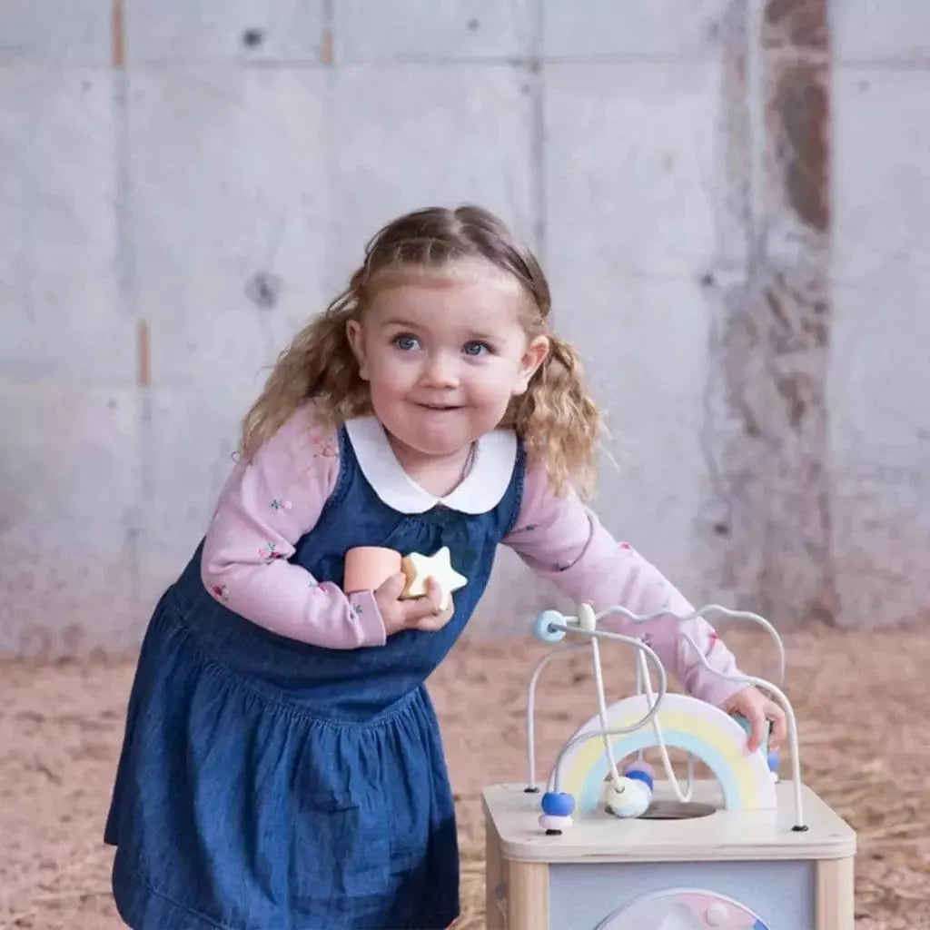little girl next to Classic World Wooden Dream Activity Cube