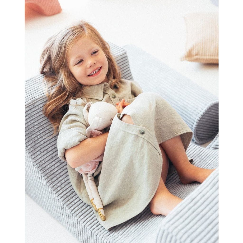 smiling girl lying on Wigiwama Peppermint Green Rainbow Softplay Set