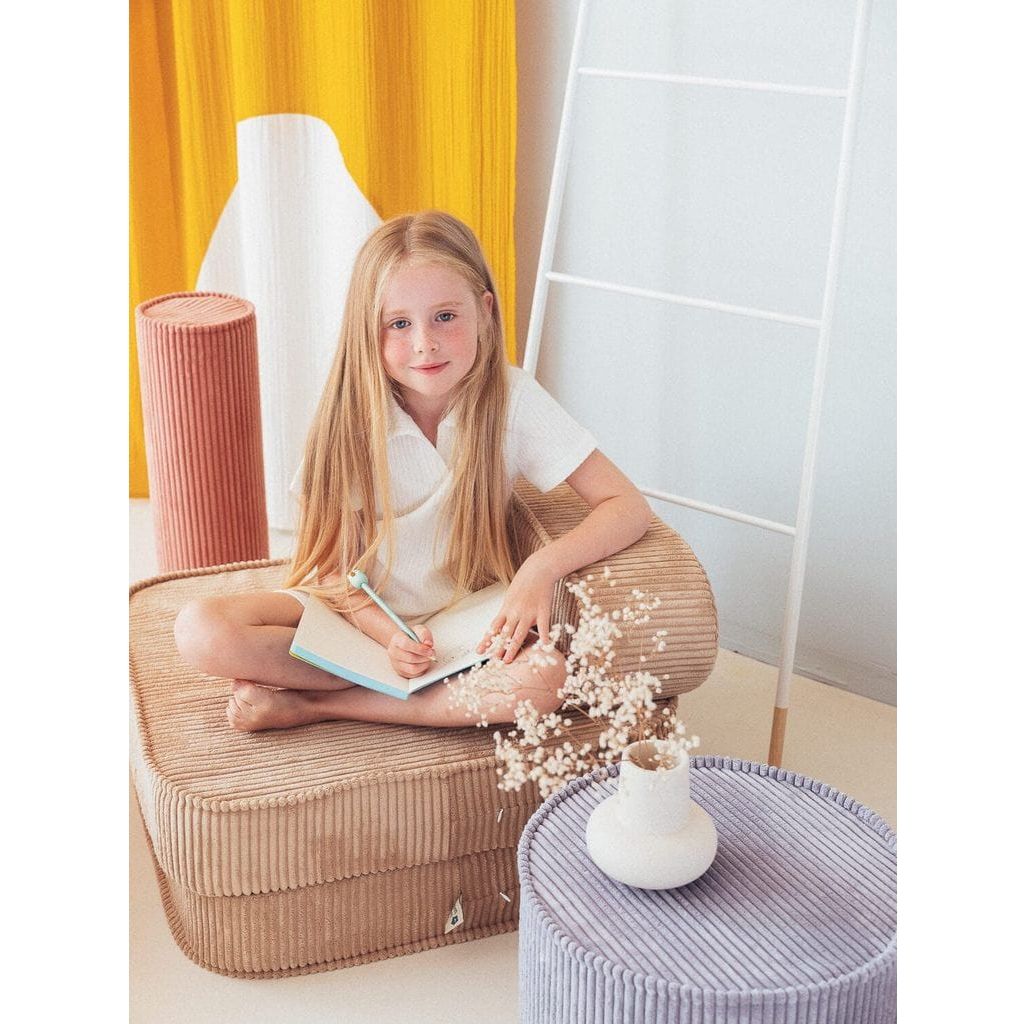girl sitting on Wigiwama Brown Sugar Flip Chair writing in notebook