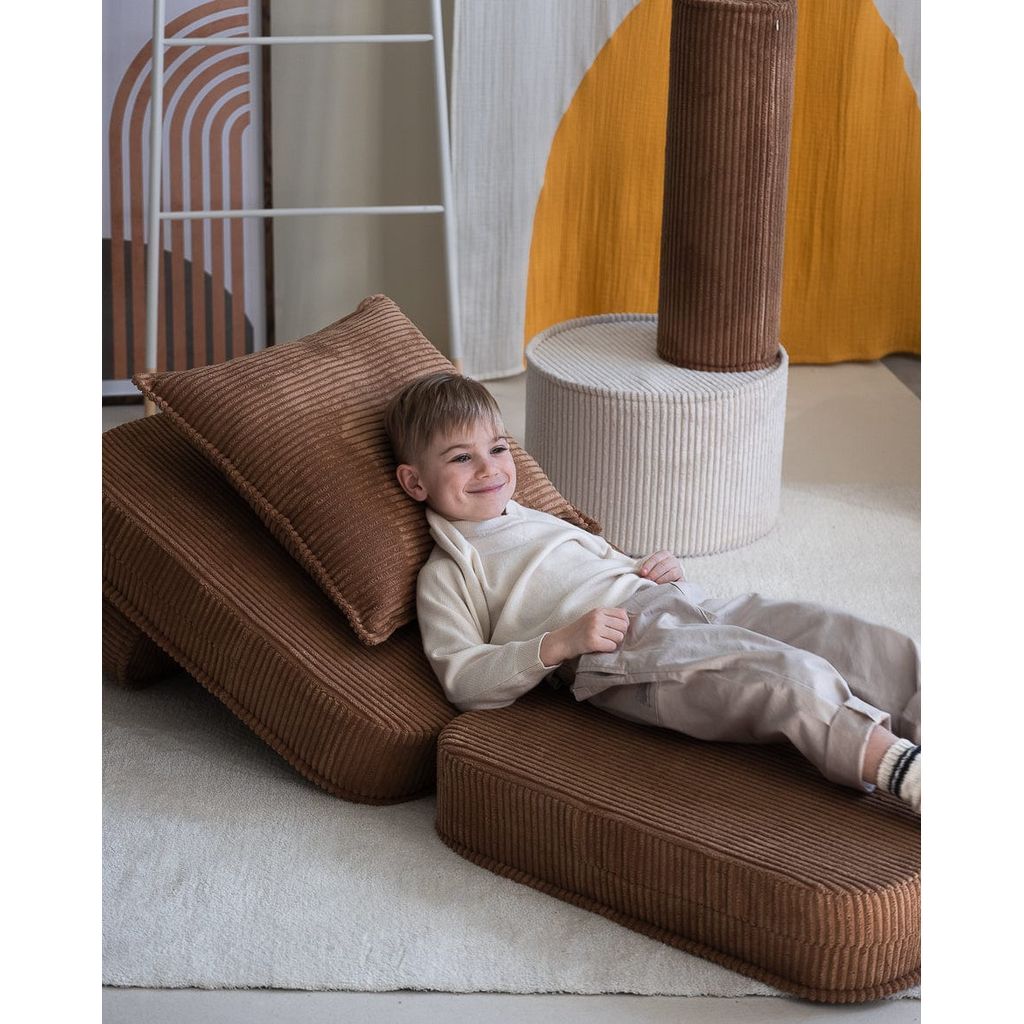 boy lying on Wigiwama flip chair with Toffee Block Cushion kids furniture