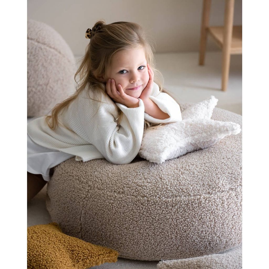 girl leaning on ottoman with Wigiwama Cream White Star Cushion