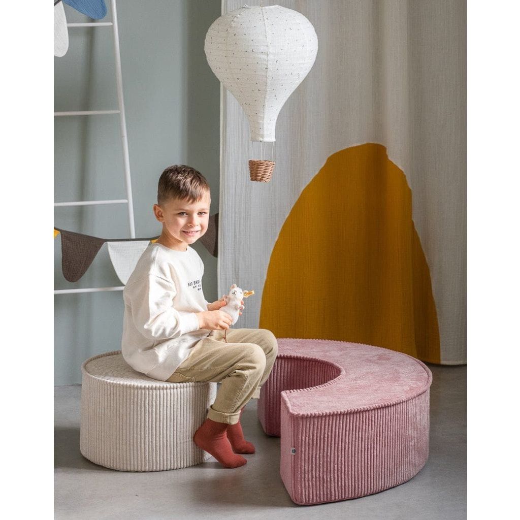 boy sitting on Wigiwama Pink Mousse Pouffe Set