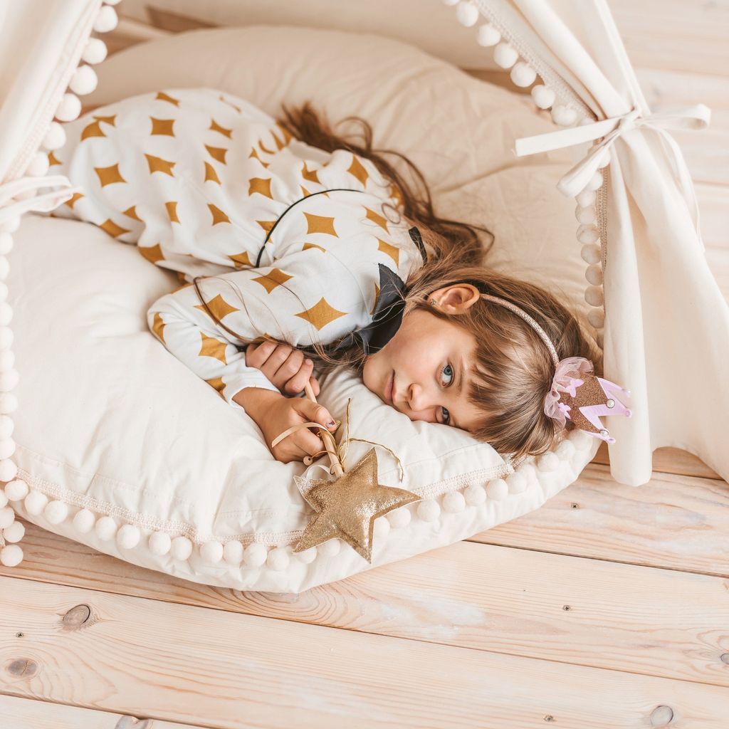 girl with wand lying on MINICAMP Large Floor Cushion With Pom Poms