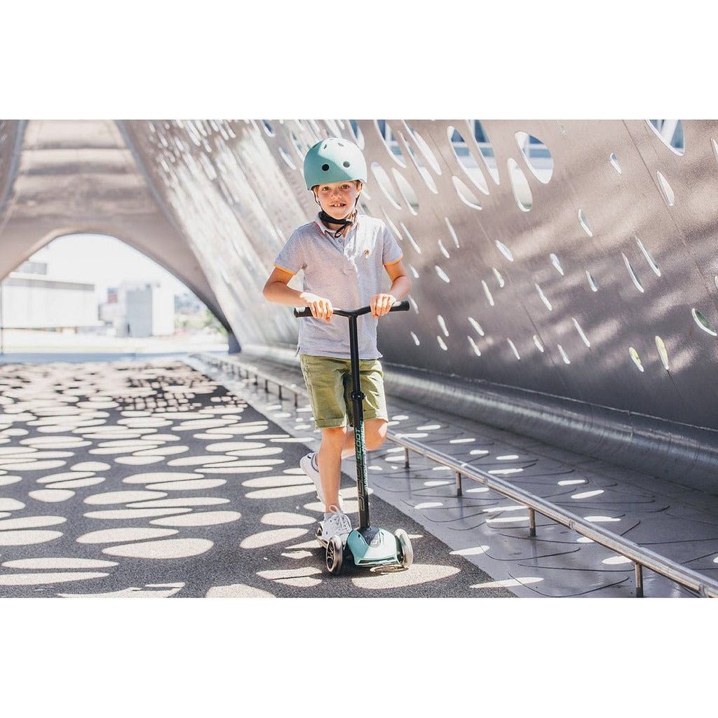 boy riding Scoot and Ride Highwaykick 5 Scooter - Led Forest with matching helmet