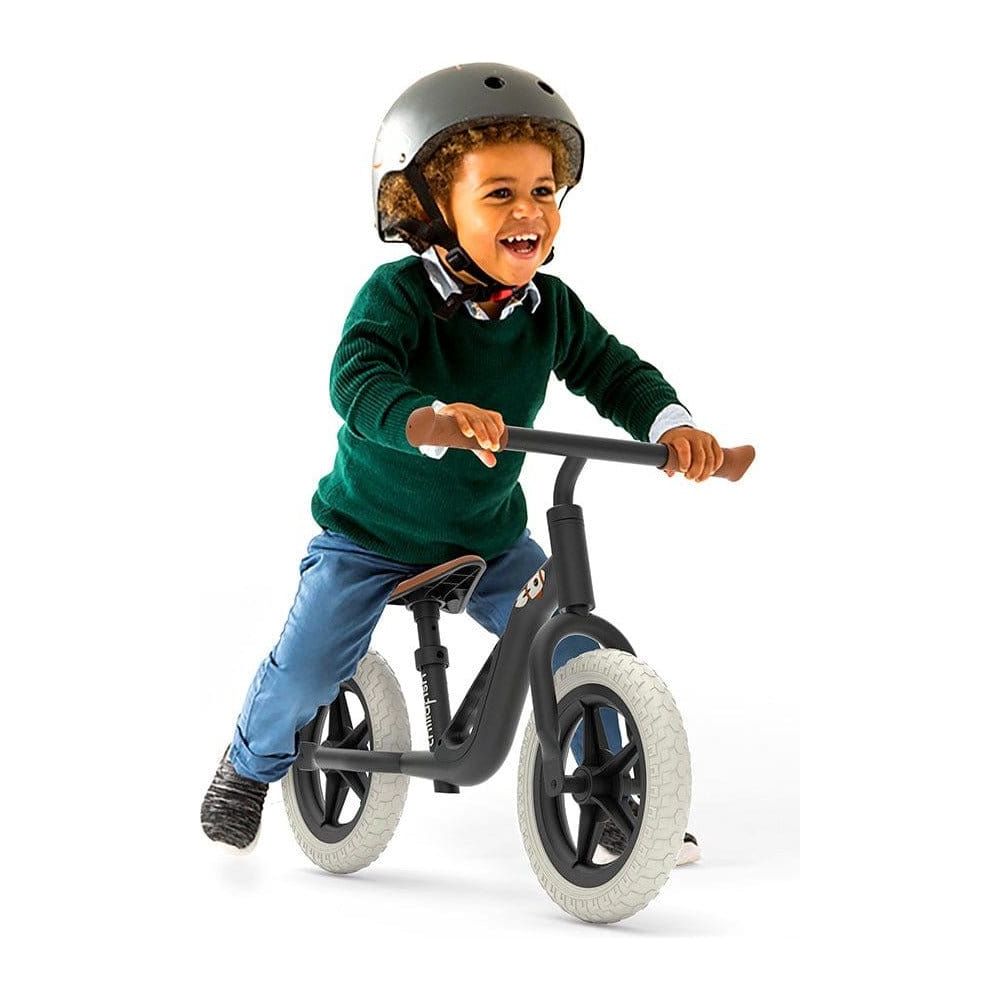 Smiling boy riding Chillafish Charlie Balance Bike 18M-4Y in Black