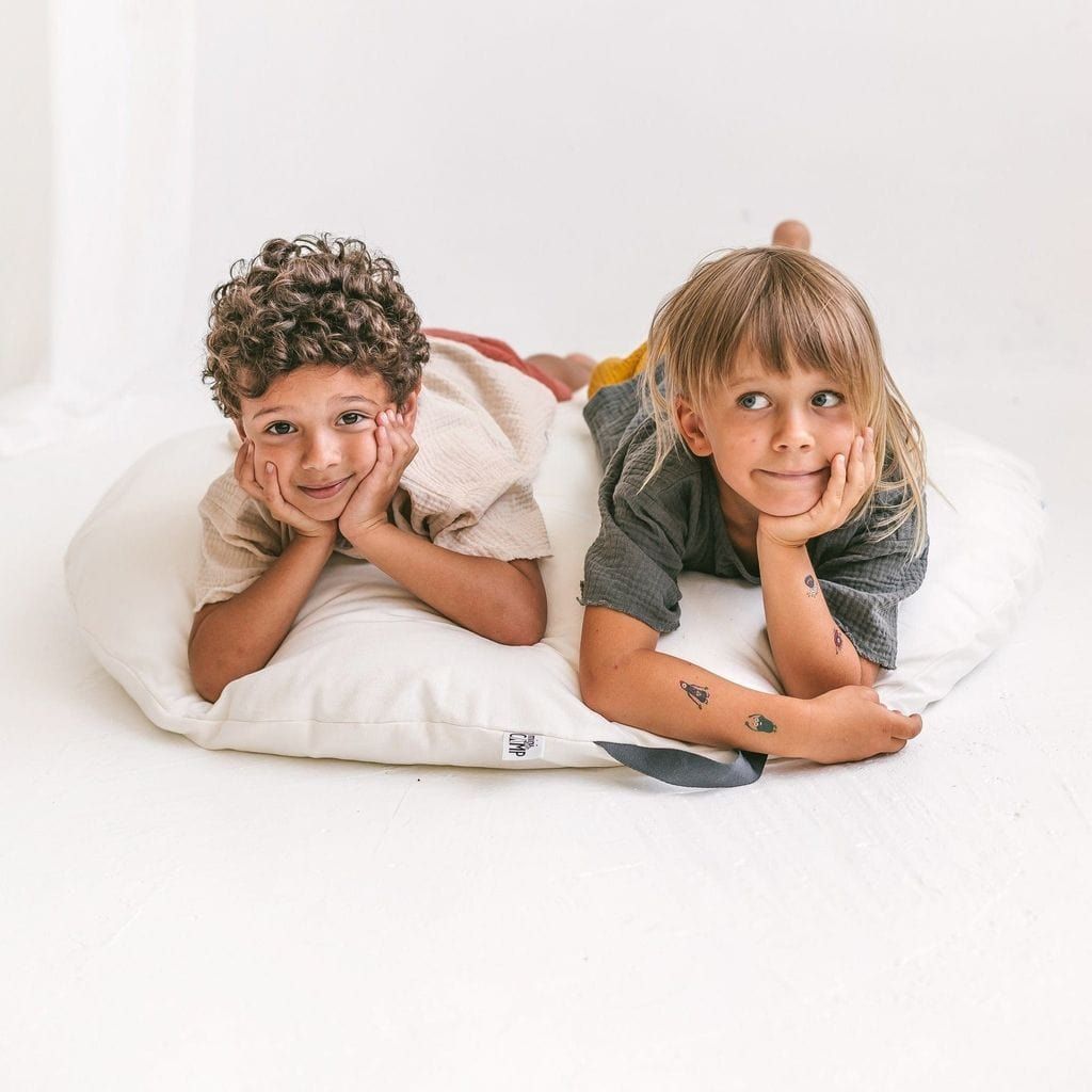 boy and girl lying on MINICAMP Lounger Floor Pillow With Handle