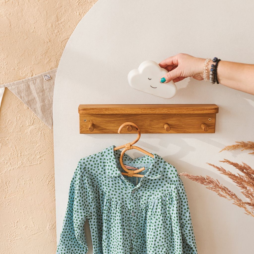 MINICAMP Floating Kids Bookshelf With Coat Hooks Made of Solid Oak with hanging shirt and cloud ornament