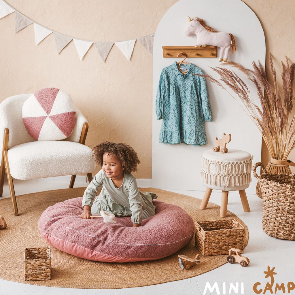 gierl sitting on oversized floor cushion in front of MINICAMP Floating Kids Bookshelf With Coat Hooks Made of Solid Oak