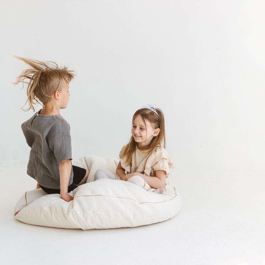 boy and girl sitting on MINICAMP Boucle Fabric Kids Floor Cushion in Ecru