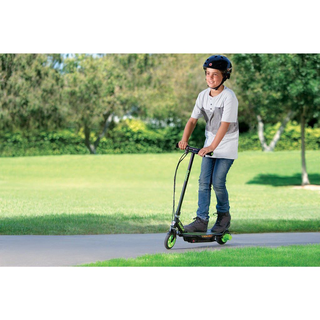 boy riding Razor Power Core E90 12 Volt Scooter - Green on path