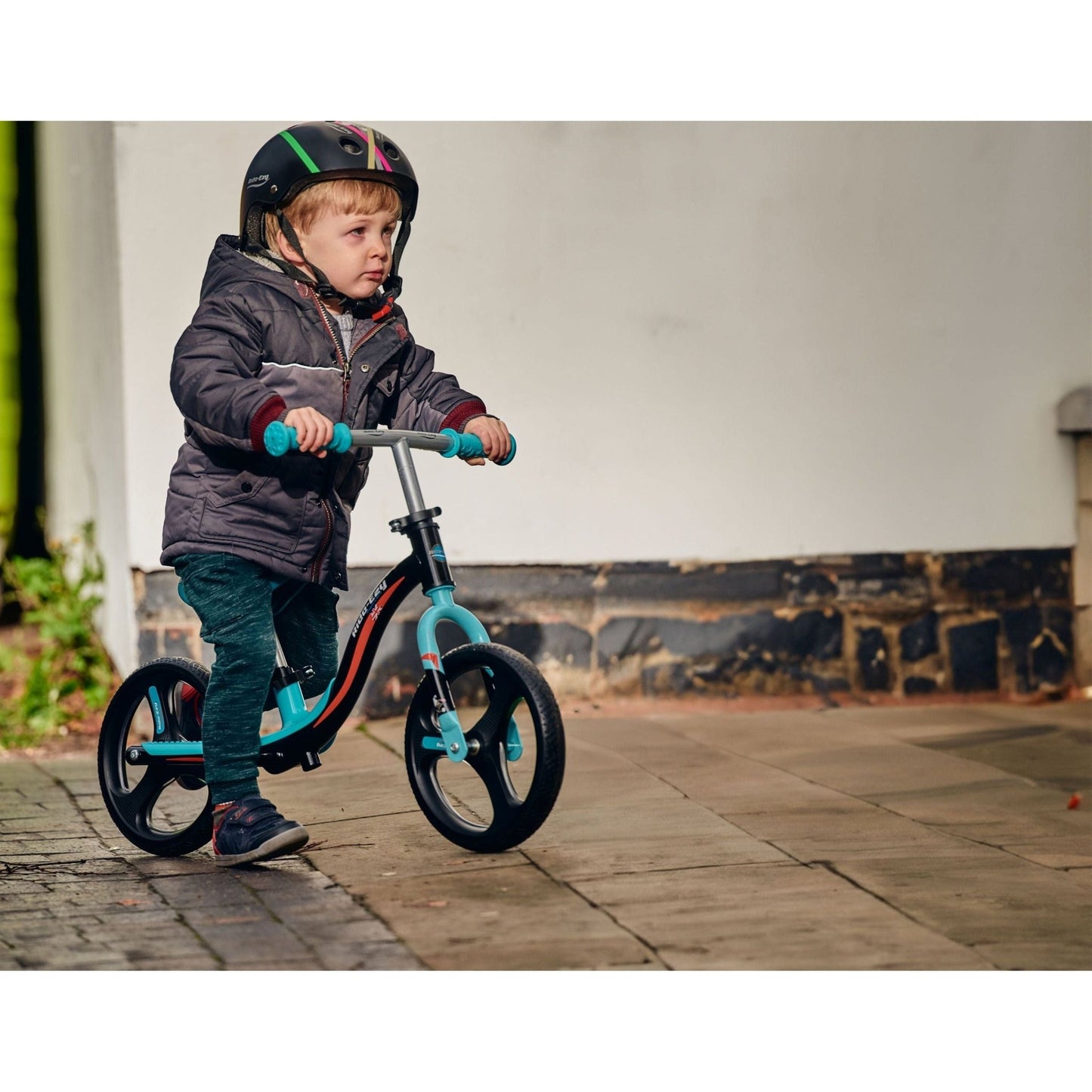 close up of boy sitting on Ride-Ezy Go Glo Balance Bike - Black & Celeste Green