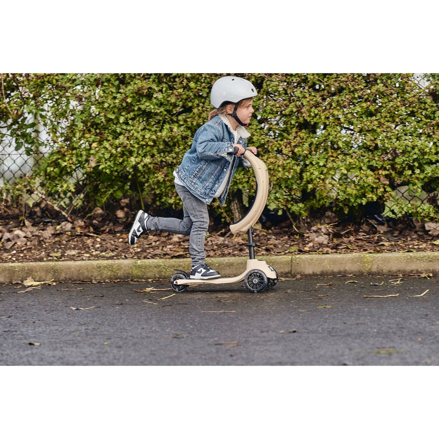 girl riding ride-ezy scooter and earing Ride-Ezy Hector 48-53cms Kids Helmet - Sandy