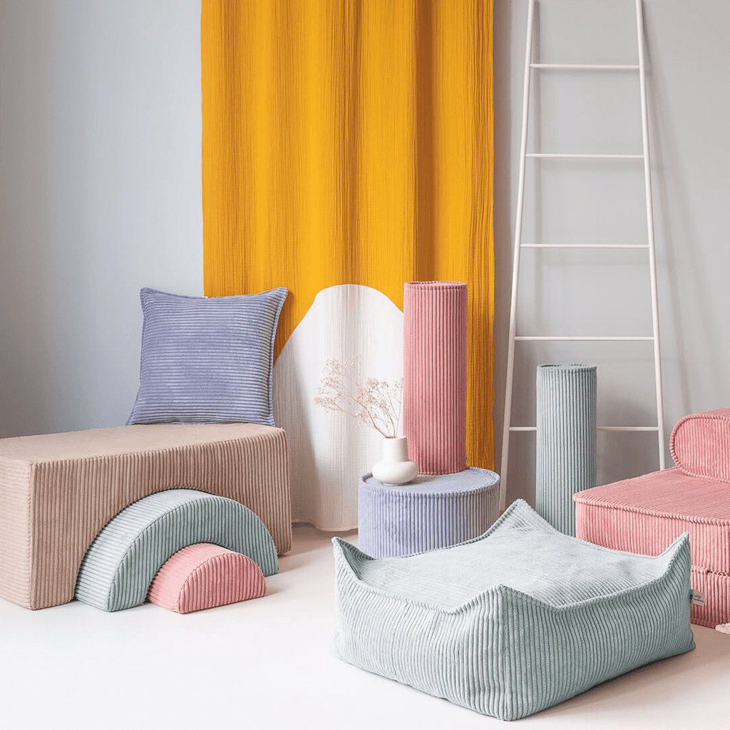 Wigiwama Brown Sugar Rainbow Playset in room with ottoman and bolster cushions