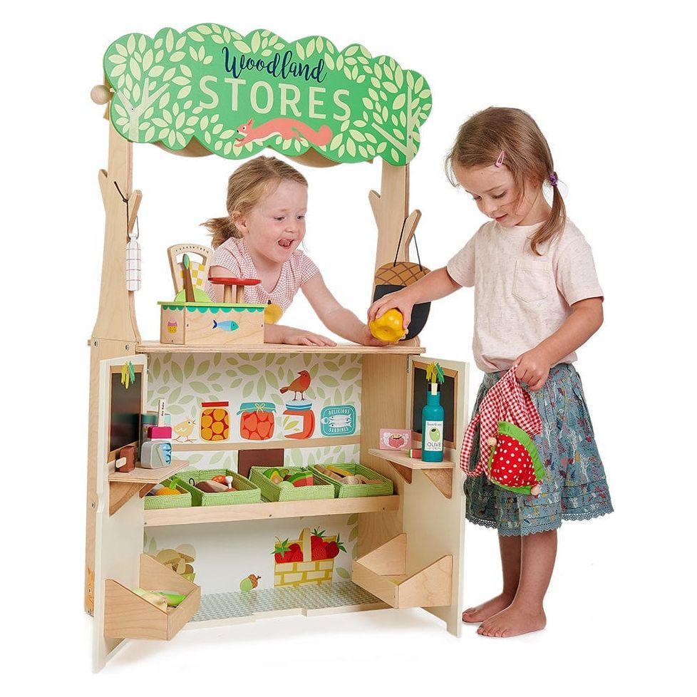 2 girls playing with store of the Tender Leaf Woodland Stores & Theatre wooden toy