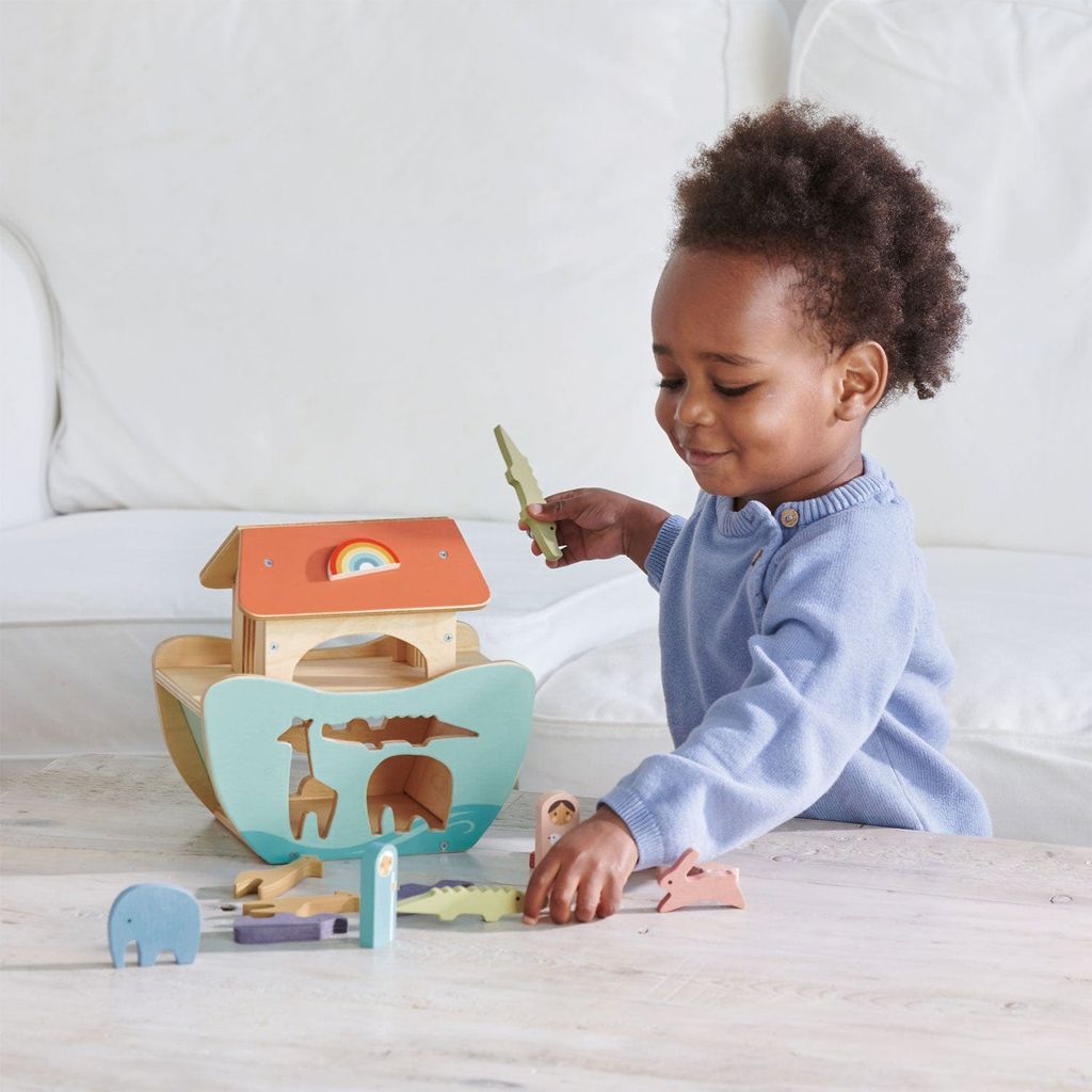 child sitting at table playing with Tender Leaf Little Noah's Ark Wooden Set