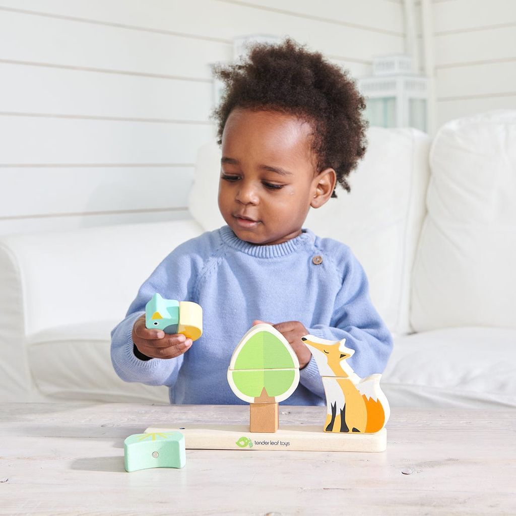 boy holding wooden toy from ThreadBear Fox Magnetic Stacker & Where's Baby Activity Book