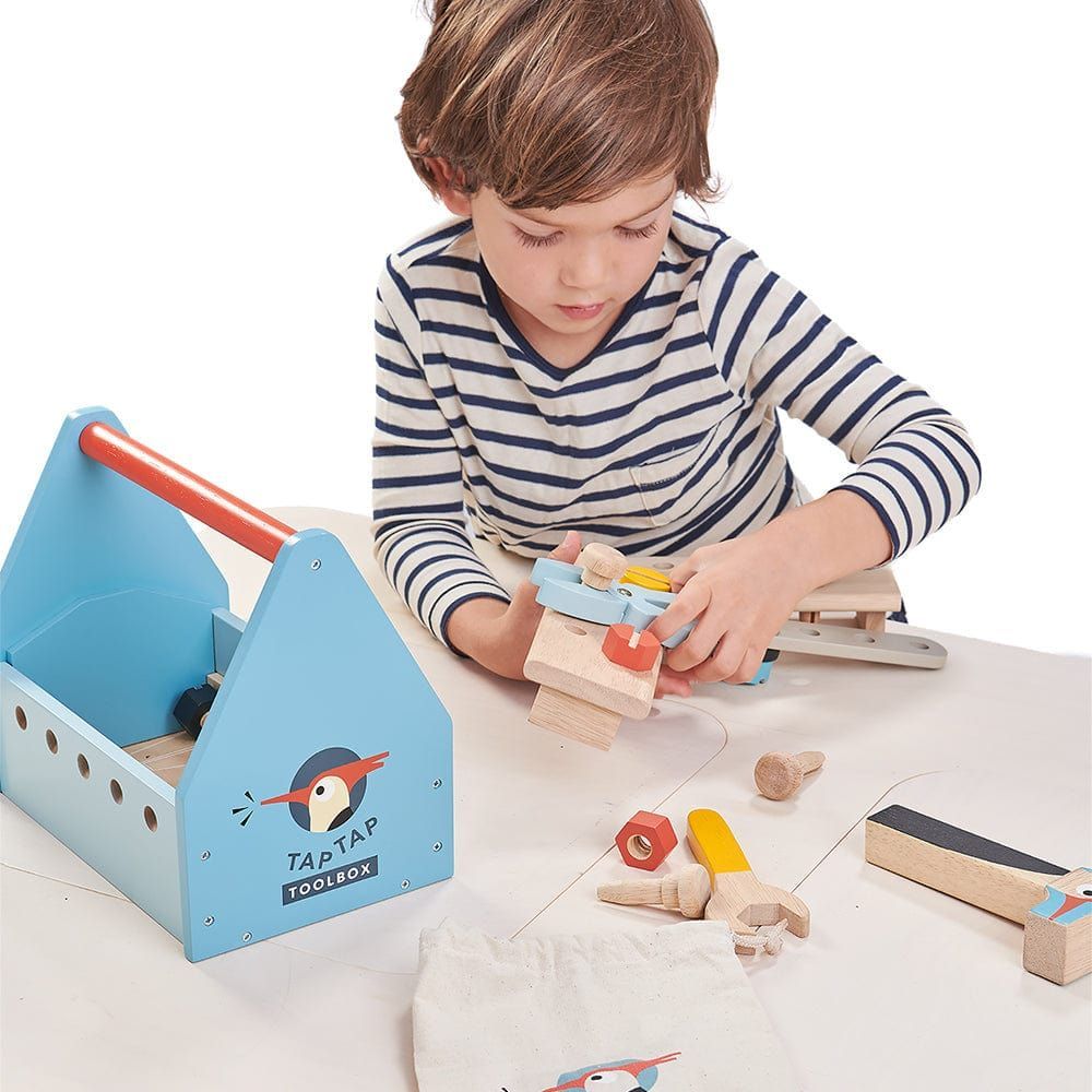boy sitting at table playing with Tender Leaf Tap Tap Wooden Tool Box