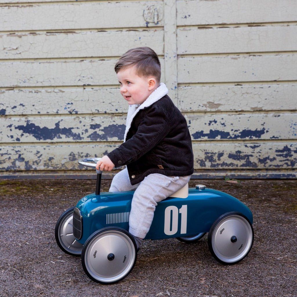 littlke boy riding Vilac Classic Ride-On Racing Car - 18m+ - Petrol Blue