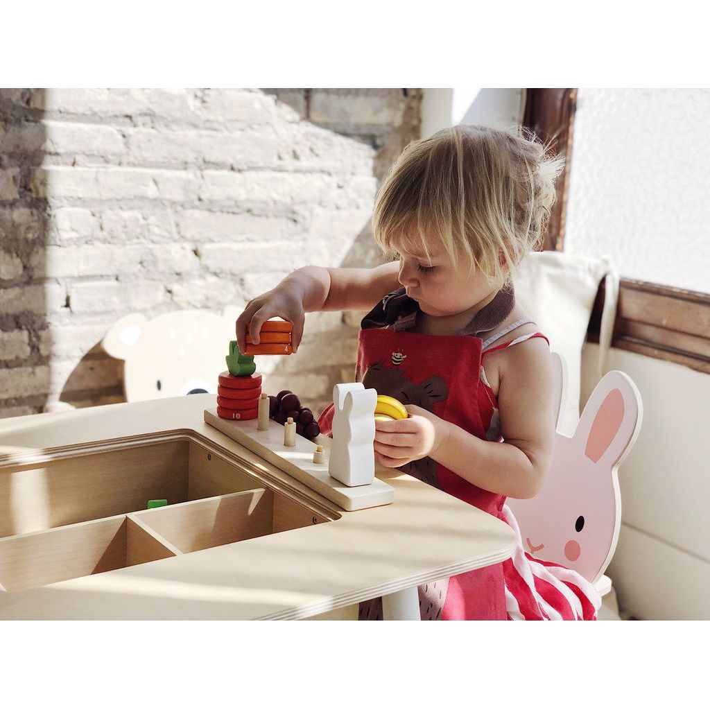 girl at table playing with Tender Leaf Counting Carrots Wooden Counting Game