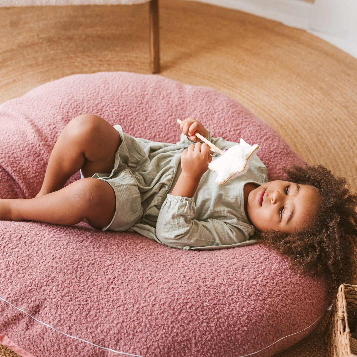 giel lying on MINICAMP Boucle Fabric Kids Floor Cushion in Rose