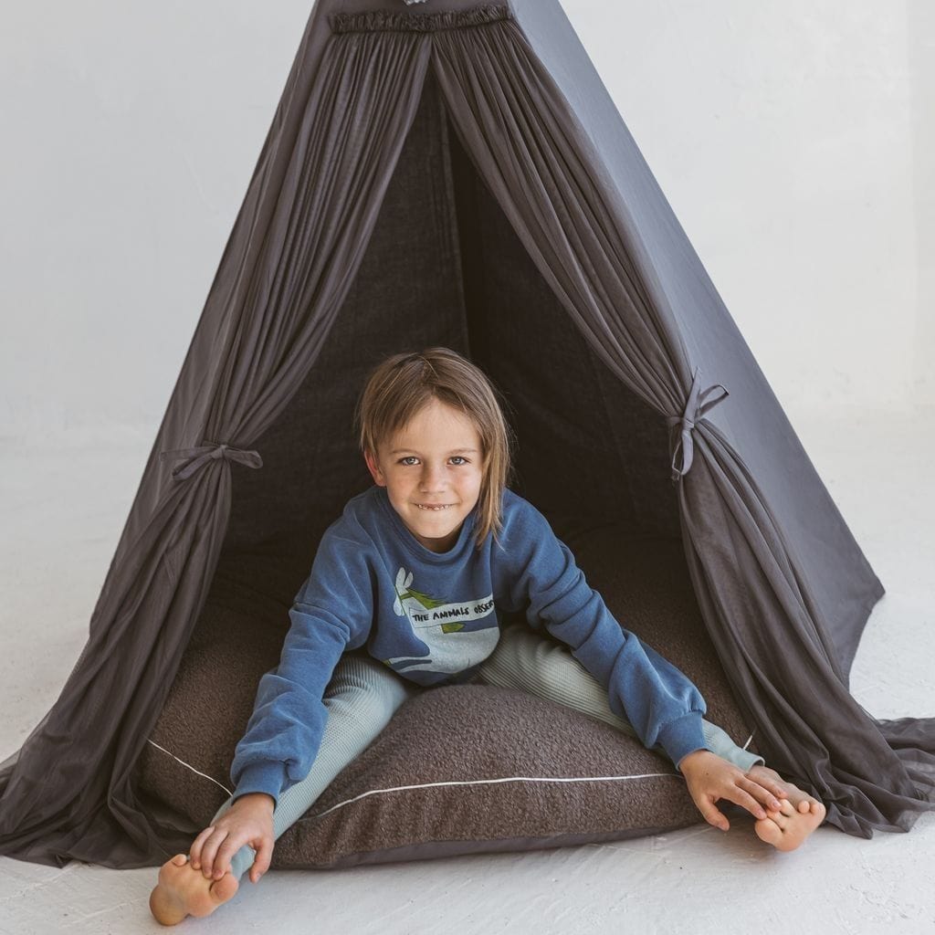 child sitting on MINICAMP Boucle Fabric Kids Floor Cushion in Grey inside kids teepee play tent