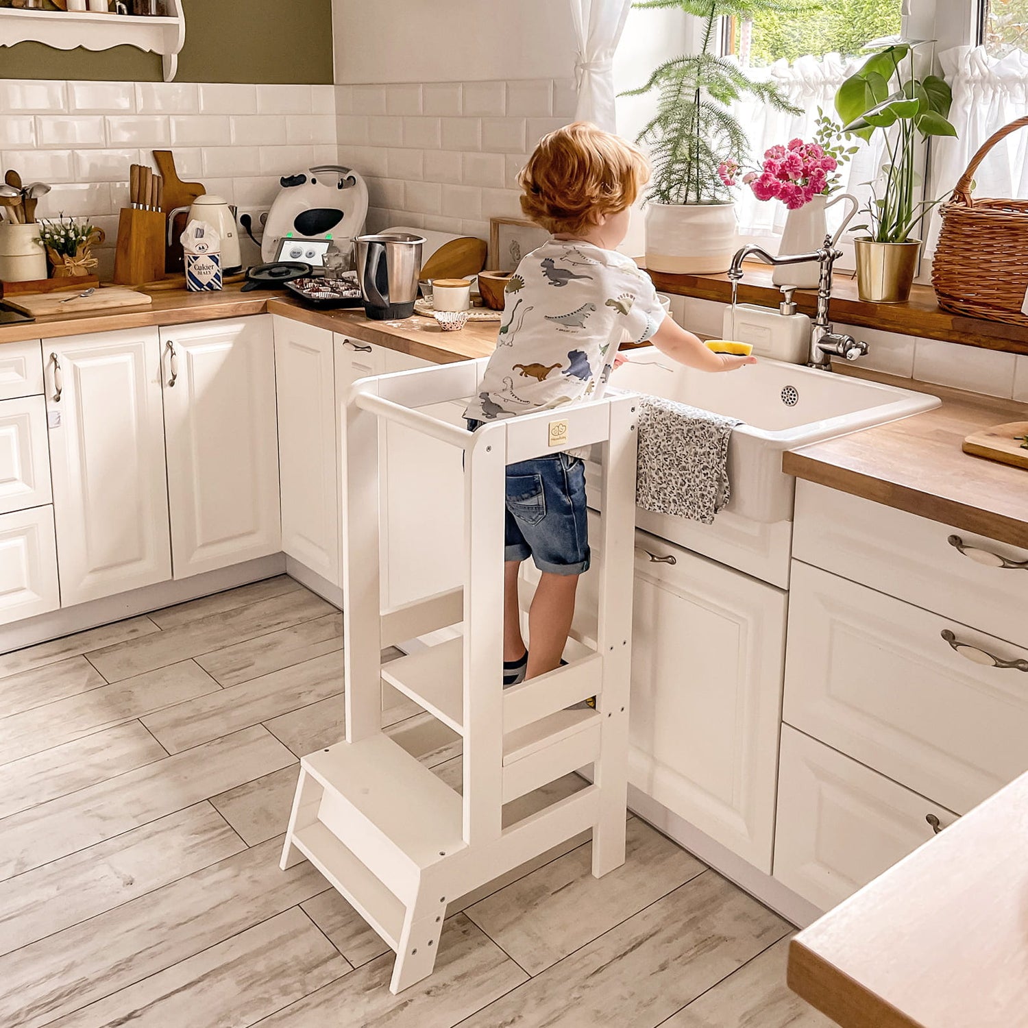 boy standing on meowbaby kitchen helper learning tower in white