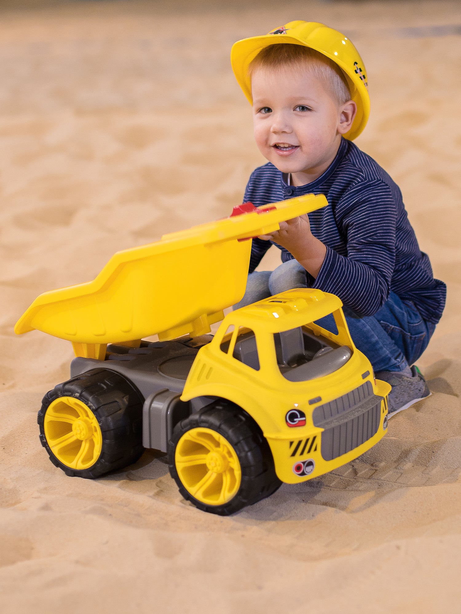smiling boy in sandpit with smoby maxi truck