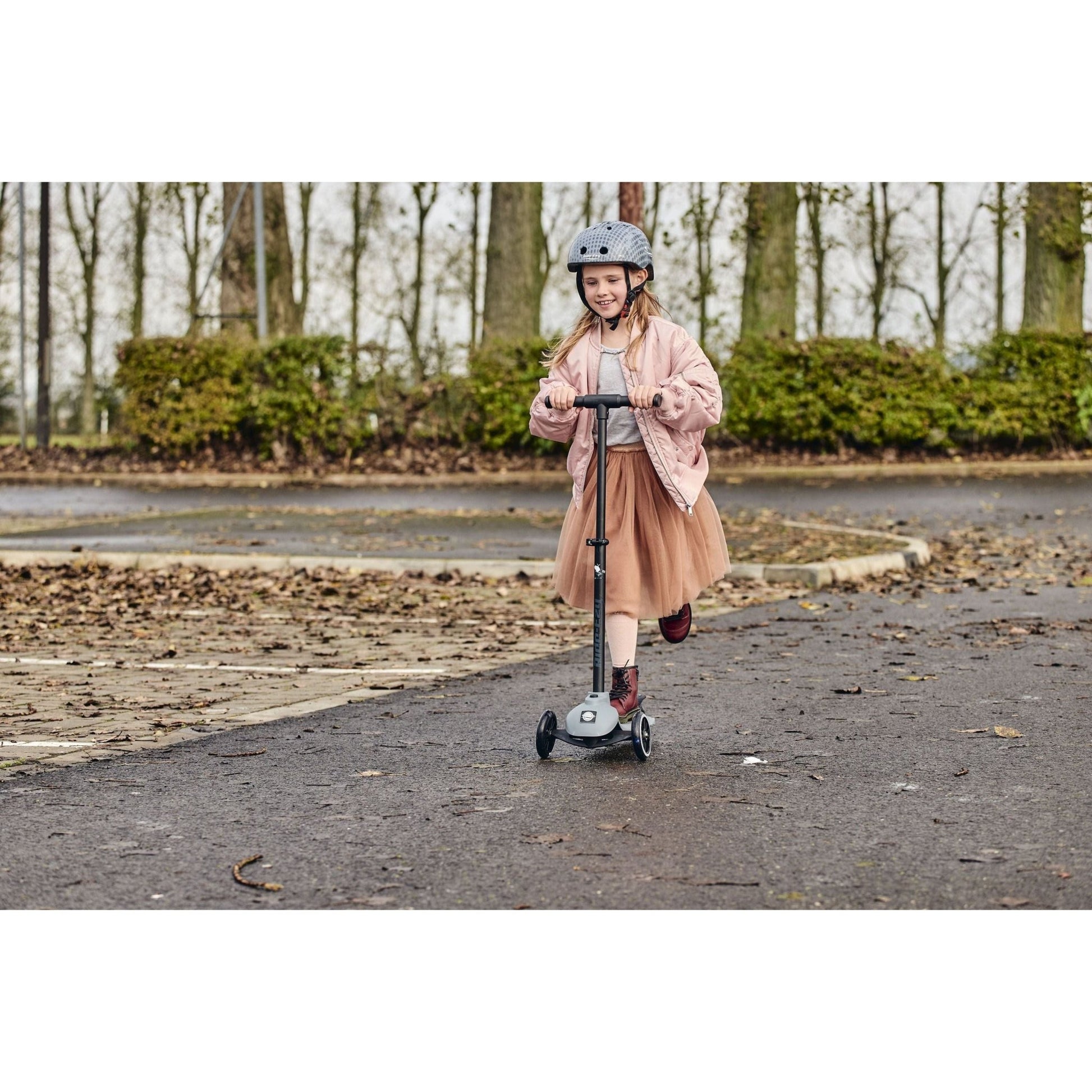 smiling girl riding Ride-Ezy Kick Scooter - Thunder Clouds in carpark