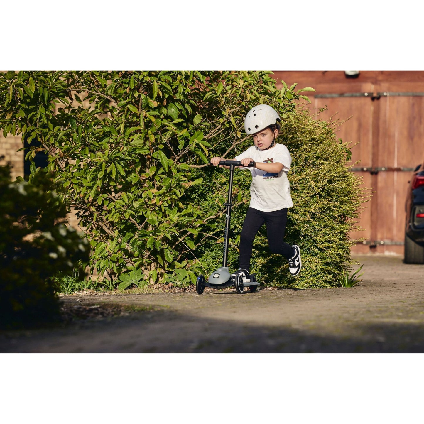 child riding Ride-Ezy Kick Scooter - Thunder Clouds on pathway