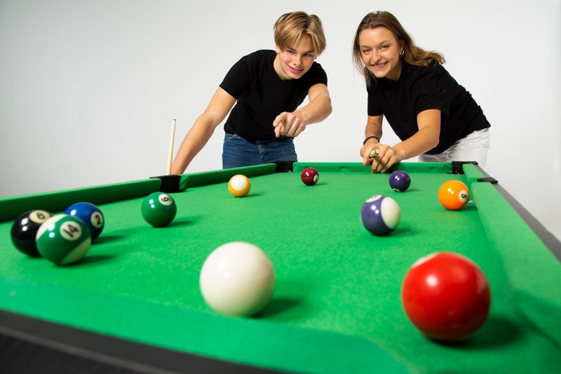 man and woman playing pool on gamesson games table