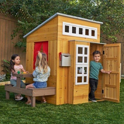 boy coming out of KidKraft Modern Outdoor Playhouse