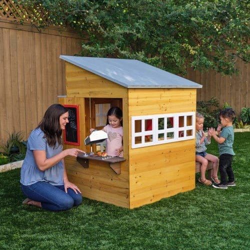woman and children playing with KidKraft Modern Outdoor Playhouse in garden