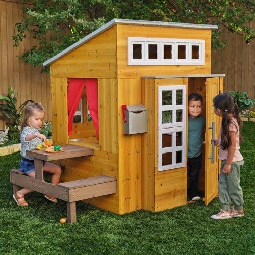 girl opening door of KidKraft Modern Outdoor Playhouse