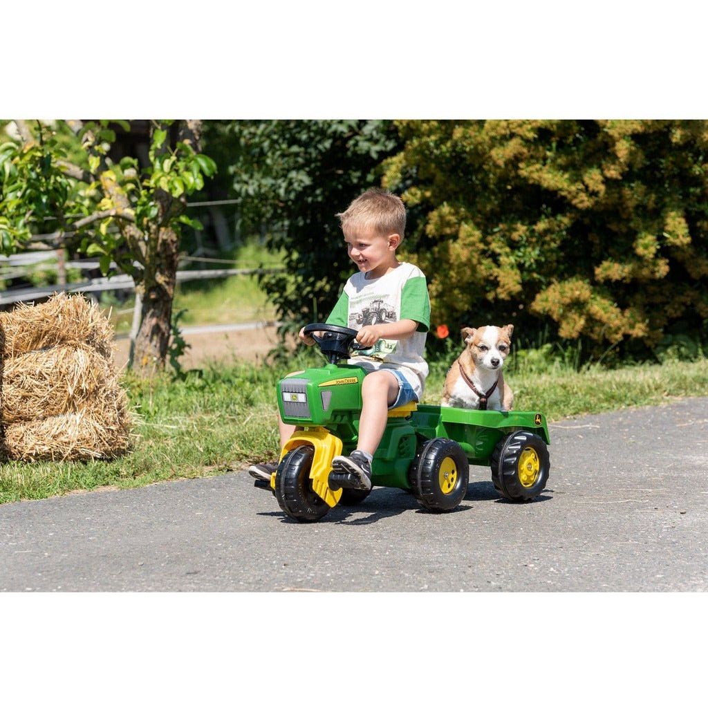 boy riding Rolly Toys John Deere Trio Trac with Electronic Steering Wheel & Trailer with dog in trailer