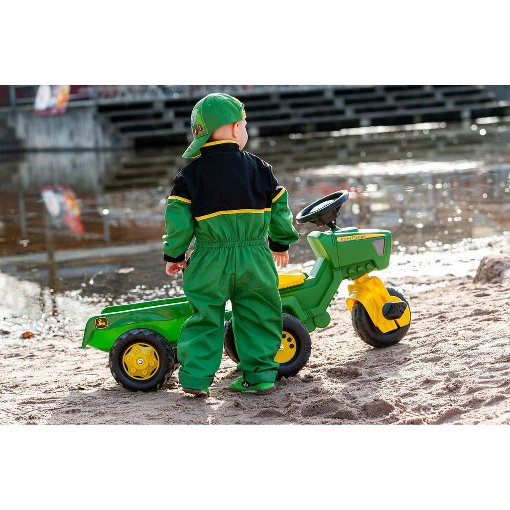 boy standing next to Rolly Toys John Deere Trio Trac with Electronic Steering Wheel & Trailer