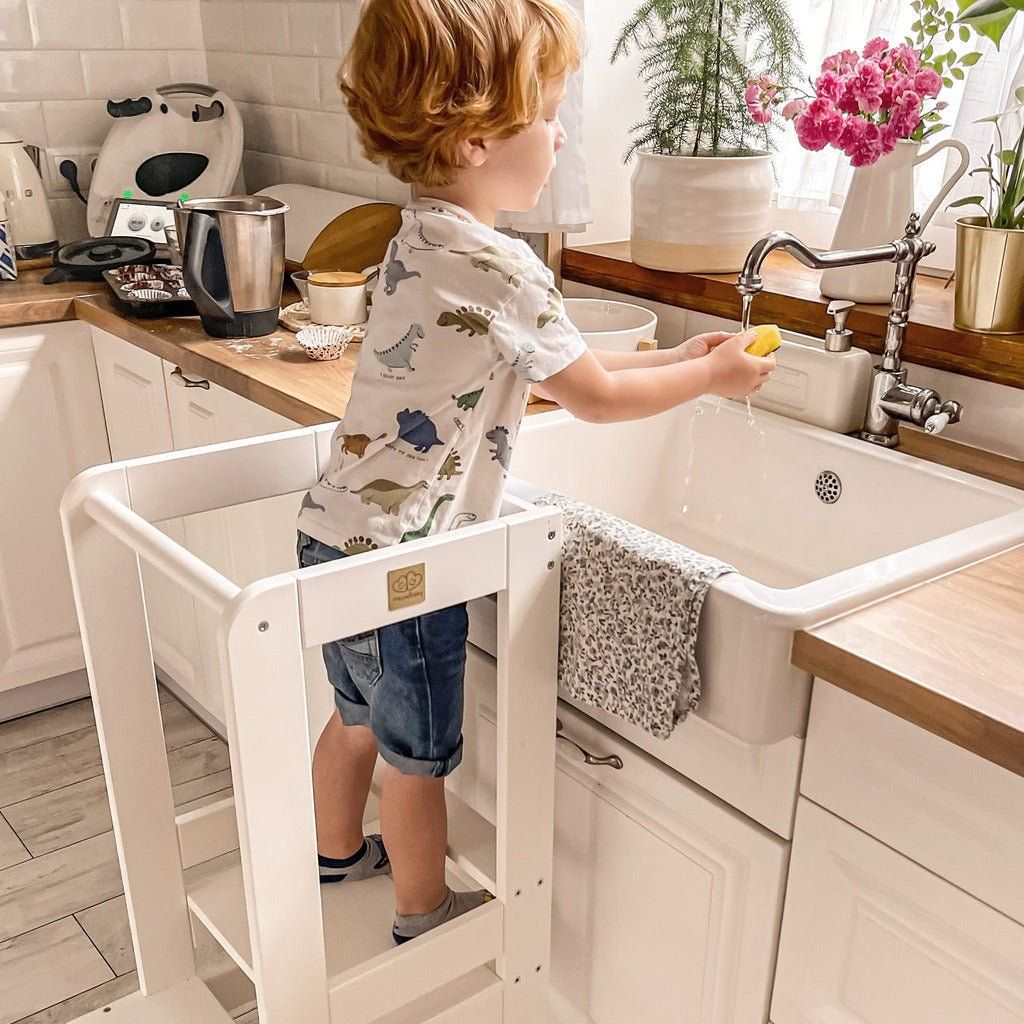 boy using Wooden Kitchen Helper - Learning Tower - White to wash hands