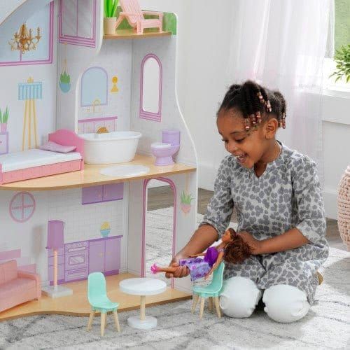 smiling girl playing with doll in Kidkraft Elise Dollhouse