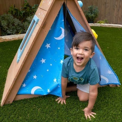 boy leaning our of curtains of KidKraft A-Frame Hideaway & Climber