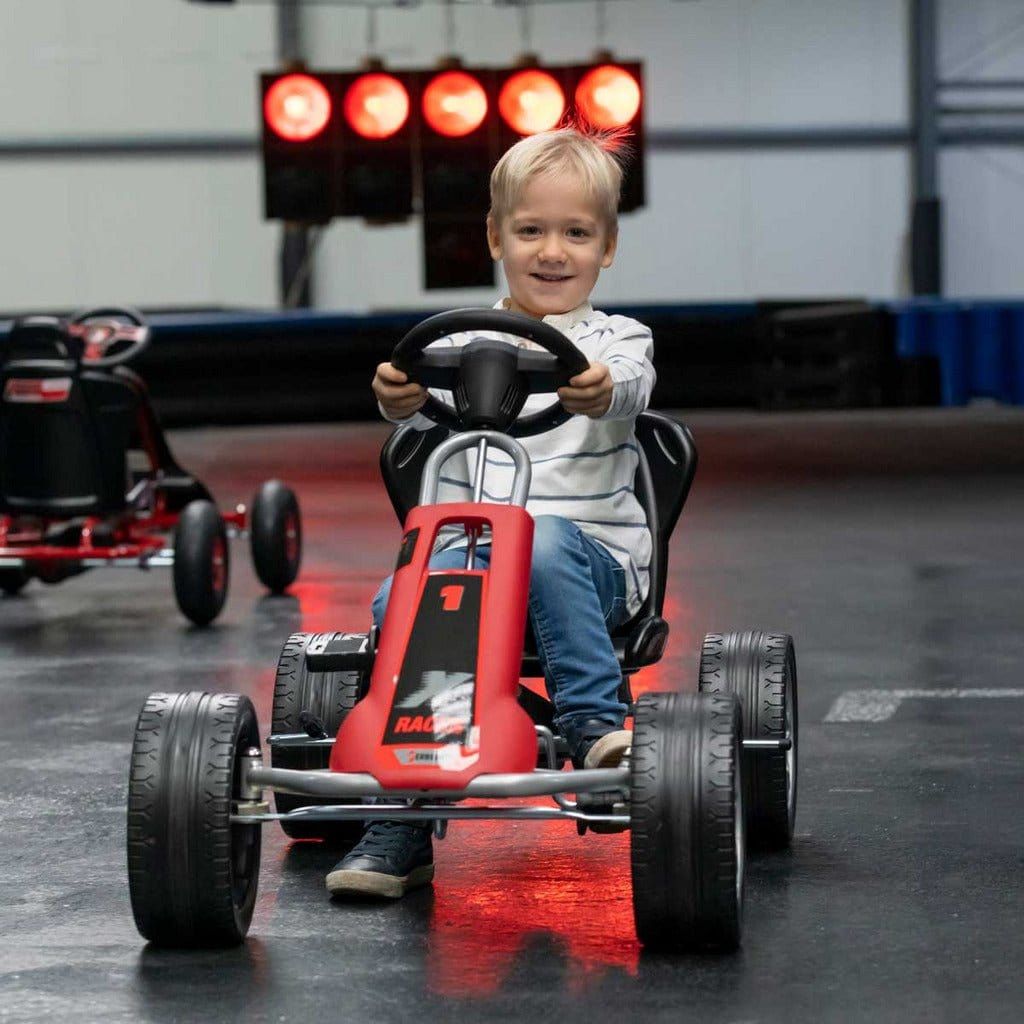 boy on race track in red Ferbedo X-Racer Go Kart with red lights behind
