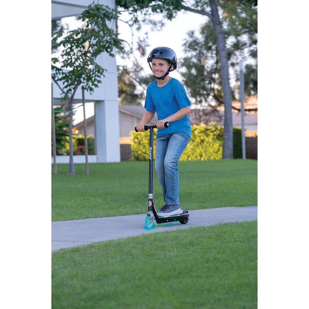 boy riding Razor Electric Tekno 10.8V Lithium-ion Scooter - Black on pavement