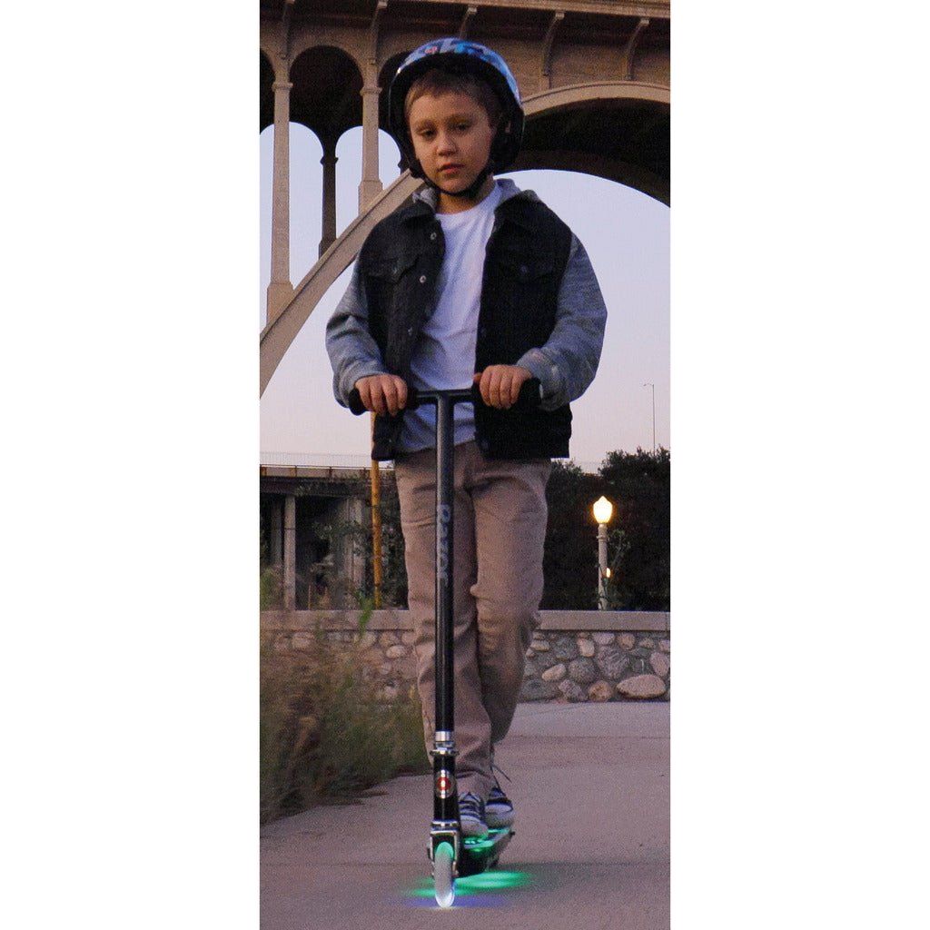 boy standing on Razor Electric Tekno 10.8V Lithium-ion Scooter - Black with lights on